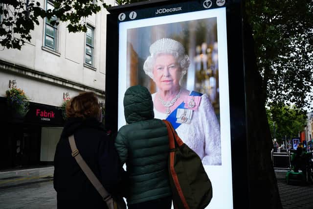 People look at a tribute to Queen Elizabeth II on Queen Street, in Cardiff, following the death of Queen Elizabeth II on Thursday. Picture date: Friday September 9, 2022.