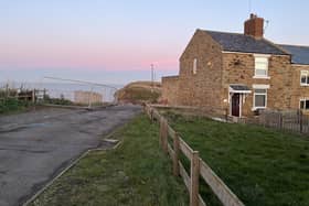 A view of the lane before it descends into Staithes harbour via Cowbar Bank with the end cottage due to be demolished seen on the right.