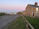 A view of the lane before it descends into Staithes harbour via Cowbar Bank with the end cottage due to be demolished seen on the right.