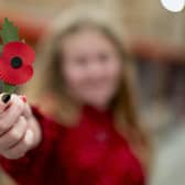 Maisie Mead, 12, a Poppy Appeal collector from Plymouth, holding the new plastic-free paper poppy. PIC: Jordan Pettitt/PA Wire