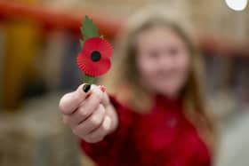 Maisie Mead, 12, a Poppy Appeal collector from Plymouth, holding the new plastic-free paper poppy. PIC: Jordan Pettitt/PA Wire