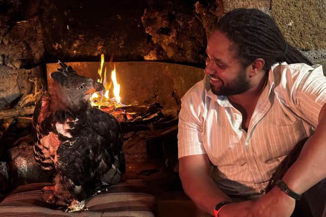 Hamza Yassin sits at the fireside with a rescued African Crowned Eagle, Helen. Picture credit: BBC/Silverback Films/Pauline Kyalo