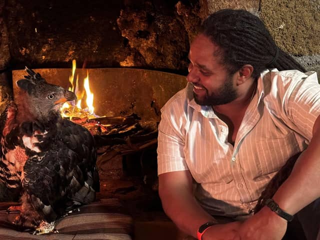 Hamza Yassin sits at the fireside with a rescued African Crowned Eagle, Helen. Picture credit: BBC/Silverback Films/Pauline Kyalo