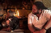 Hamza Yassin sits at the fireside with a rescued African Crowned Eagle, Helen. Picture credit: BBC/Silverback Films/Pauline Kyalo