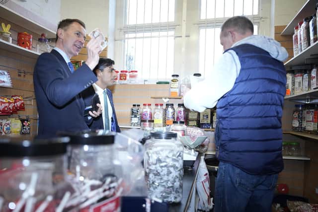 Chancellor Jeremy Hunt (left) and Prime Minister Rishi Sunak (centre) purchase sweets during a community project visit to Accrington Market Hall in Lancashire