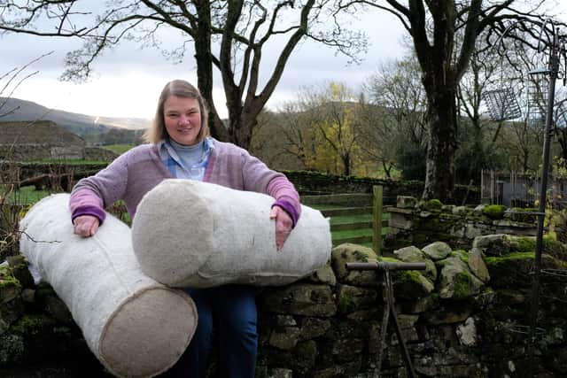 Ruth Lindsey with two of the woollen logs she is making for use in peatland restoration.