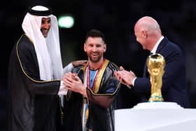Lionel Messi of Argentina is presented with a traditional robe by Sheikh Tamim bin Hamad Al Thani, Emir of Qatar, while Gianni Infantino, President of FIFA, looks on during the awards ceremony after the FIFA World Cup Qatar 2022 Final match between Argentina and France (Picture: Clive Brunskill/Getty Images)