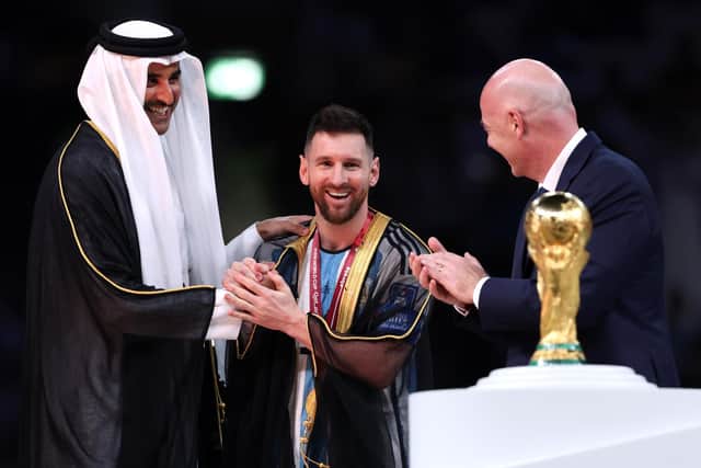 Lionel Messi of Argentina is presented with a traditional robe by Sheikh Tamim bin Hamad Al Thani, Emir of Qatar, while Gianni Infantino, President of FIFA, looks on during the awards ceremony after the FIFA World Cup Qatar 2022 Final match between Argentina and France (Picture: Clive Brunskill/Getty Images)