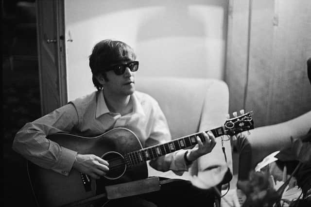 John Lennon plays the guitar in a hotel room in Paris in 1964 (Photo: Harry Benson/Express/Hulton Archive/Getty Images)