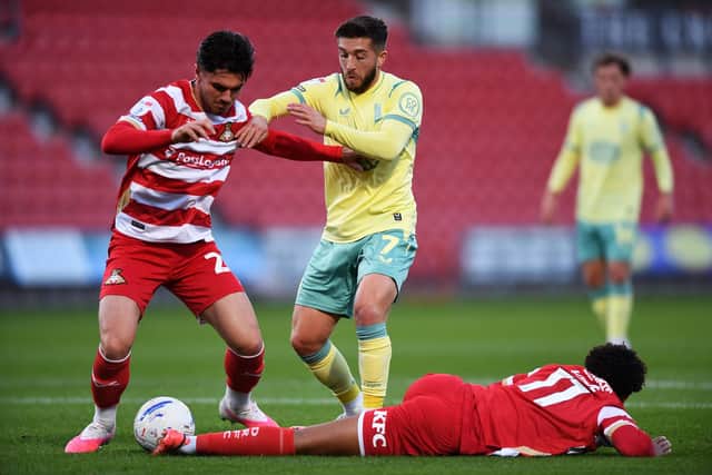 Doncaster Rovers midfielder Darren Robinson takes on Huddersfield Town's Lynden Gooch. Picture: Jonathan Gawthorpe