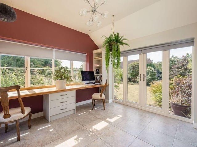 A wood-burning stove, tiled floor and oak-topped desk make this a versatile additional living space.