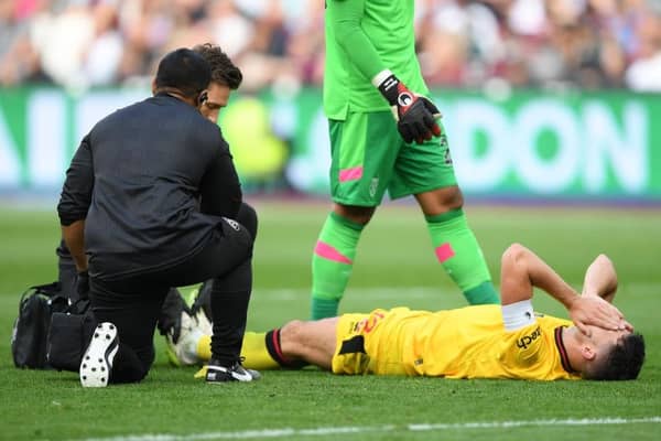 PAIN: Sheffield United captain John Egan receives treatment during September's Premier League match at West Ham United
