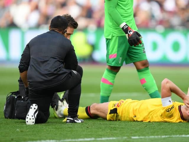 PAIN: Sheffield United captain John Egan receives treatment during September's Premier League match at West Ham United