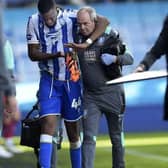 Sheffield Wednesday midfielder Momo Diaby leaves the field during the second half on Saturday with the help of Doctor Richard Higgins. Picture: Steve Ellis.