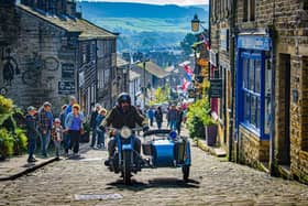 A motorcycle and sidecar travel on the cobbles on Main Street in Haworth. (Pic credit: Tony Johnson)