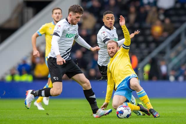 HARD GOING: Sheffield Wednesday's Barry Bannan slides in on Derby County's Max Bird during Saturday's 0-0 stalemate between the League One promotion rivals at Pride Park Picture: Bruce Rollinson