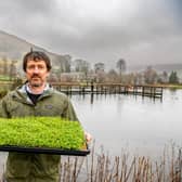 Jamie Roberts, with a tray of Alfalfa seedlings grown from bio products collected from their trout