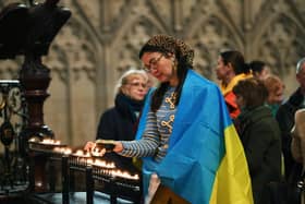 Lilia Zhukova lights a candle at the vigil held at York Minster, to mark the first anniversary of the invasion of Ukraine by Russian forces.24th February 2023.