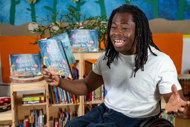 Ade Adepitan holding a copy of The Secret Garden Under The Sea. Photo: James Pinniger/PA.
