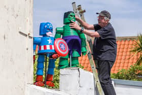 Tony Harwood positions his superheroes Captain America and The Hulk he has made for Flamborough Flowerpot Festival.