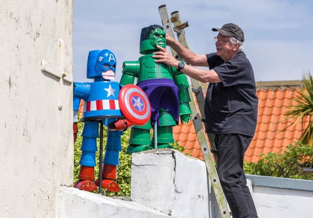 Tony Harwood positions his superheroes Captain America and The Hulk he has made for Flamborough Flowerpot Festival.