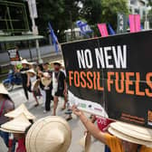 A protester holds a slogan as they join the global march to end fossil fuel on Friday, Sept. 15, 2023, in Quezon city, Philippines. (AP Photo/Aaron Favila)