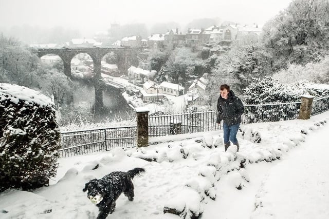 A man walks a dog in Knaresborough, North Yorkshire after snowfall.