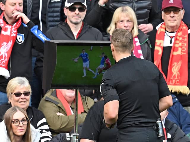 Referee Craig Pawson looks at a replay on a monitor during a VAR review, before awarding a penalty to Liverpool, during the English Premier League football match between Liverpool and Everton at Anfield in Liverpool, north west England on October 21, 2023. (Photo by Paul ELLIS / AFP) / RESTRICTED TO EDITORIAL USE. No use with unauthorized audio, video, data, fixture lists, club/league logos or 'live' services. Online in-match use limited to 120 images. An additional 40 images may be used in extra time. No video emulation. Social media in-match use limited to 120 images. An additional 40 images may be used in extra time. No use in betting publications, games or single club/league/player publications. /  (Photo by PAUL ELLIS/AFP via Getty Images)