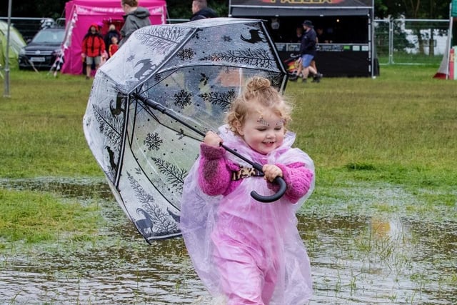 A little girl used an umbrella to shield herself from the rain.