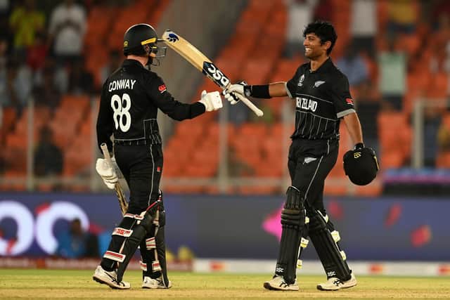Rachin Ravindra celebrates his century with Devon Conway, who also made a hundred as New Zealand romped to a thumping victory. Photo by Gareth Copley/Getty Images.