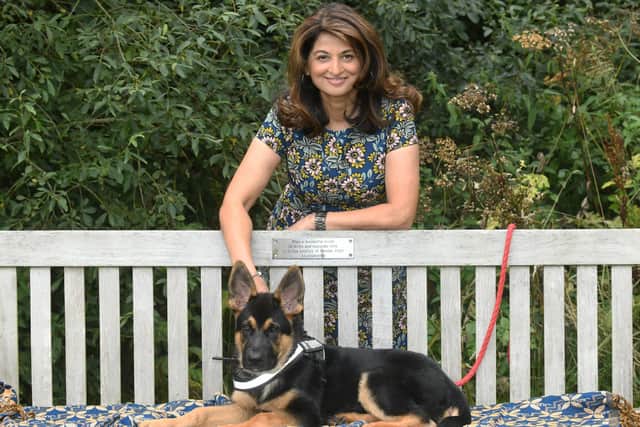 Daxa Patel by her father's memorial bench in Golden Acre park in Leeds with her puppy Oscar.