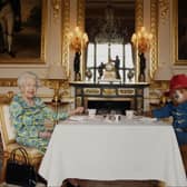 Queen Elizabeth II and Paddington Bear having cream tea at Buckingham Palace taken from a film that was shown at the BBC Platinum Party at the Palace. Copyright: PA/Buckingham Palace/ Studio Canal / BBC Studios.
