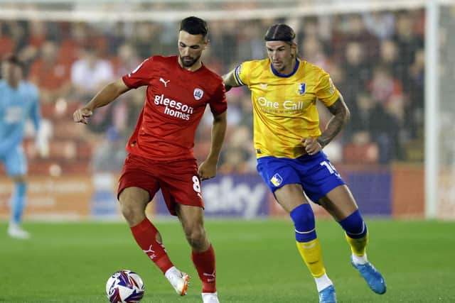 Barnsley’s Adam Phillips (left) and Mansfield Town’s Aden Flint battle for the ballduring the Sky Bet League One match at Oakwell. Photo: Nigel French/PA Wire.