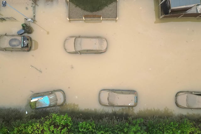 In this aerial view, water damaged cars are seen as flood waters begin to recede in the village of Catcliffe.