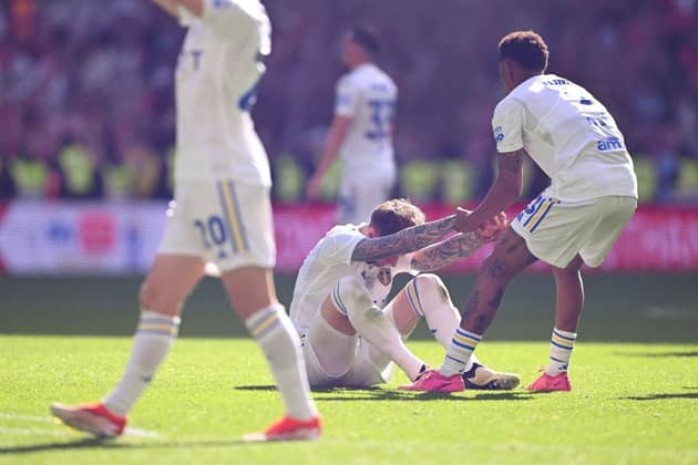 LONDON, ENGLAND - MAY 26: Joe Rodon of Leeds United is picked up by Junior Firpo as they react after defeat to Southampton during the Sky Bet Championship Play Final match between Leeds United and Southampton at Wembley Stadium on May 26, 2024 in London, England. (Photo by Mike Hewitt/Getty Images)