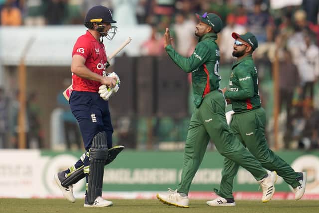 Howzat: Bangladesh players celebrate as England's captain Jos Buttler, left, walks off the field after losing his wicket on the way to a shock defeat for the world T20 champions. (AP Photo/Aijaz Rahi)