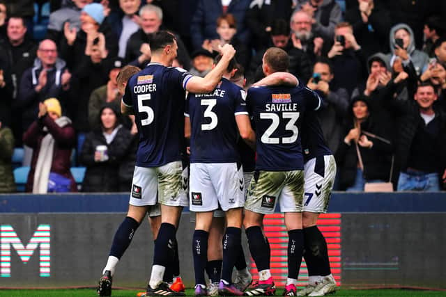 Millwall's Tom Bradshaw celebrates scoring their side's second goal of the game with team-mates during the Sky Bet Championship match at The Den, London. Picture date: Saturday February 18, 2023.