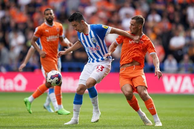 Huddersfield Town's Yuta Nakayama (left) and Blackpool's Jerry Yates battle for the ball (Picture: PA)