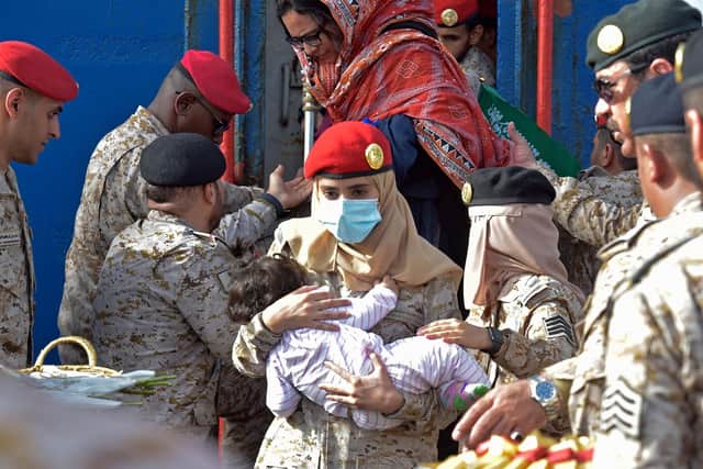 Members of the Saudi Navy Forces assist evacuees arriving at King Faisal navy base in Jeddah on April 26, 2023 following a rescue operation from Sudan amid a US-brokered ceasefire between the country's warring generals. - Fighting broke out in Sudan on April 15 between forces loyal to army chief Abdel Fattah al-Burhan and his deputy turned rival Mohamed Hamdan Daglo, who commands the powerful paramilitary Rapid Support Forces (RSF). (Photo by Amer HILABI / AFP) (Photo by AMER HILABI/AFP via Getty Images)