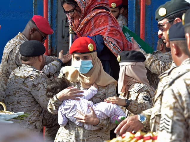 Members of the Saudi Navy Forces assist evacuees arriving at King Faisal navy base in Jeddah on April 26, 2023 following a rescue operation from Sudan amid a US-brokered ceasefire between the country's warring generals. - Fighting broke out in Sudan on April 15 between forces loyal to army chief Abdel Fattah al-Burhan and his deputy turned rival Mohamed Hamdan Daglo, who commands the powerful paramilitary Rapid Support Forces (RSF). (Photo by Amer HILABI / AFP) (Photo by AMER HILABI/AFP via Getty Images)