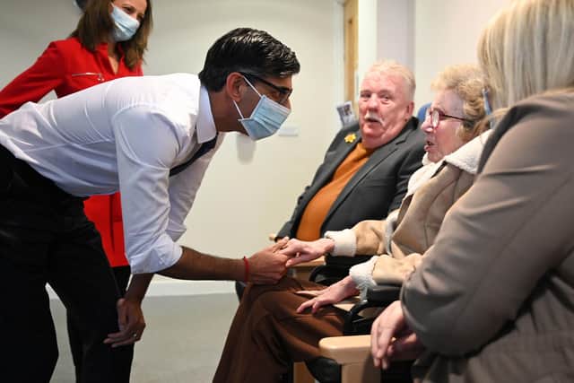 Prime Minister Rishi Sunak wearing a face mask meets with patient Pauline Burke (sitting centre) with her daughter Emma (right) and husband Patrick with Minister of State for Social Care Helen Whately (back left) during a visit to the Rutland Lodge Healthcare Centre in Leeds. Picture date: Monday January 9, 2023. PA Photo. See PA story HEALTH NHS. Photo credit should read: Oli Scarff/PA Wire