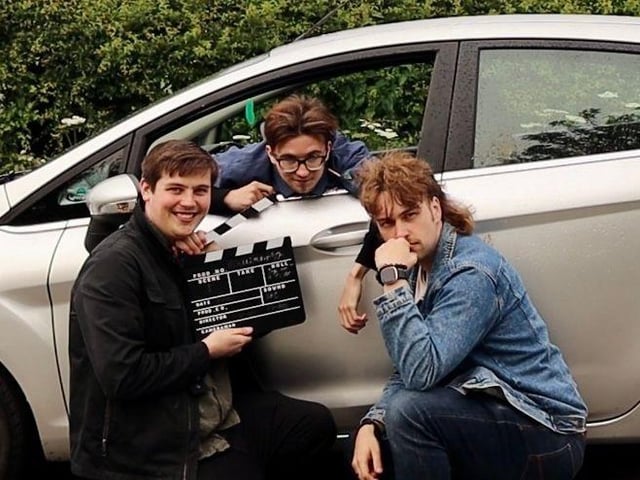 A promotional shot of one of the sketches that will feature in the film. From left to right, Leon Cole directing, Harry Lee as ‘Car Mechanic’ and Thomas Dawes and ‘Ditzy Driver’
