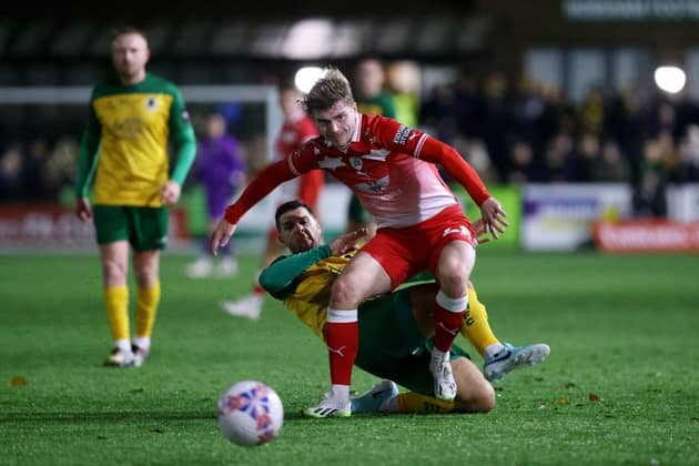 HORSHAM, ENGLAND - NOVEMBER 14: Luca Connell of Barnsley is challenged by Tommy Kavanagh of Horsham during the Emirates FA Cup First Round Replay match between Horsham and Barnsley at The Camping World Community Stadium on November 14, 2023 in Horsham, England. Photo by Charlie Crowhurst/Getty Images.