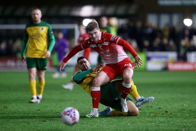 HORSHAM, ENGLAND - NOVEMBER 14: Luca Connell of Barnsley is challenged by Tommy Kavanagh of Horsham during the Emirates FA Cup First Round Replay match between Horsham and Barnsley at The Camping World Community Stadium on November 14, 2023 in Horsham, England. Photo by Charlie Crowhurst/Getty Images.