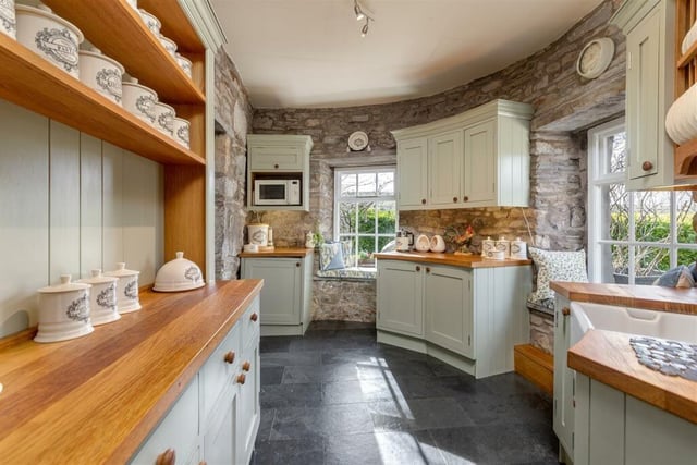 The bespoke kitchen was made by The Joinery Shop and local tradesmen, with an Italian induction hob, Range cooker and units sitting flush with the curved and exposed stone walls