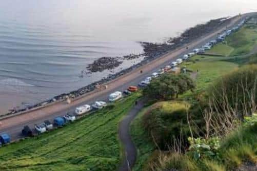 Signs on motorhome parking on the coast were thrown off the cliff by vandals, a councillor said