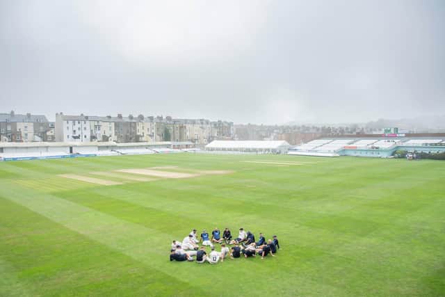 The Yorkshire players and coaches relax on the outfield after victory over Derbyshire as the sea fret rolls in at North Marine Road. Picture by Allan McKenzie/SWpix.com