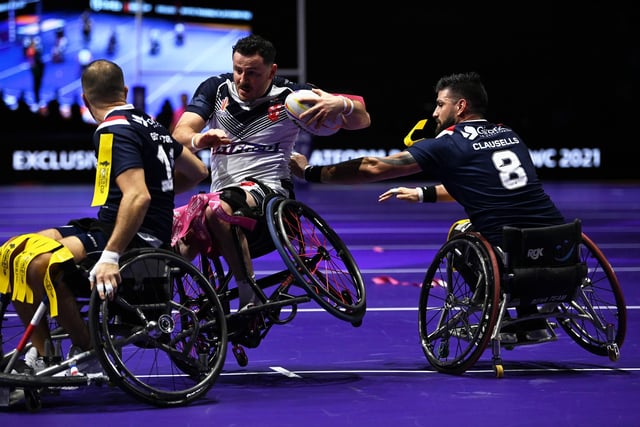 MANCHESTER, ENGLAND - NOVEMBER 18: Sebastien Bechara of England is tackled by Nicolas Clausells and Florian Guttadoro of France during the Wheelchair Rugby League World Cup Final match between France and England at Manchester Central on November 18, 2022 in Manchester, England. (Photo by Gareth Copley/Getty Images)