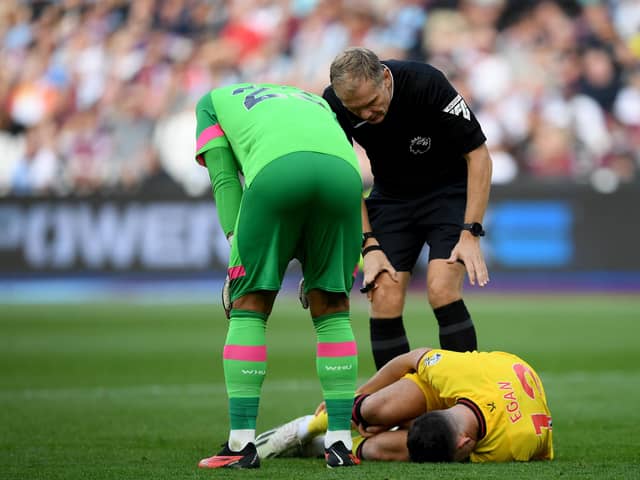Worrying sight: Sheffield United captain John Egan lays prone on the turf with injury during the Blades' 2-0 defeat against West Ham at the London Stadium (Picture:Harriet Lander/Getty Images)