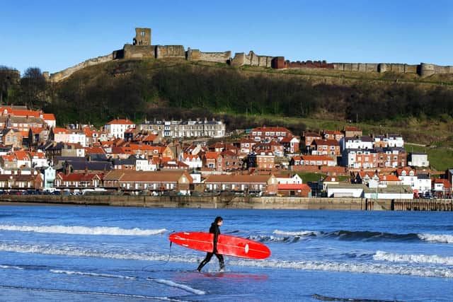 A lone surfer walks out to catch the waves at Scarborough. (Pic credit: Simon Hulme)